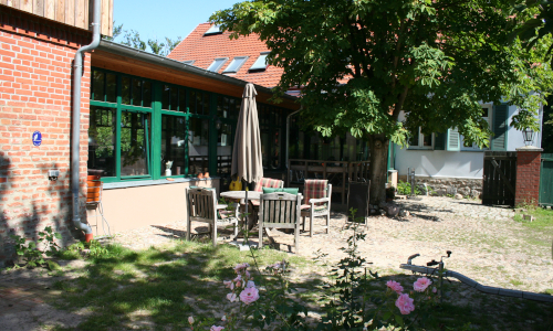 Innenhof der Katerbower Ölmühle mit Blick zum Hofladen und Terasse davor
